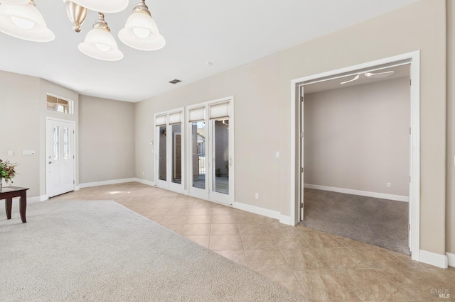 interior space with light tile patterned flooring, a notable chandelier, light colored carpet, visible vents, and baseboards