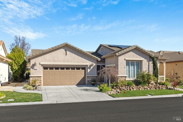 ranch-style house featuring solar panels, stucco siding, a garage, stone siding, and driveway