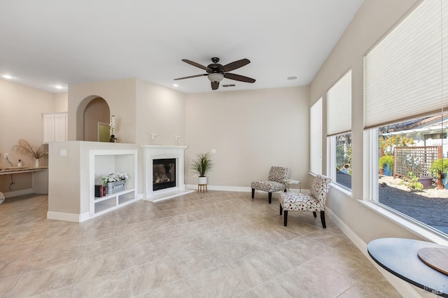 sitting room with recessed lighting, a glass covered fireplace, and baseboards