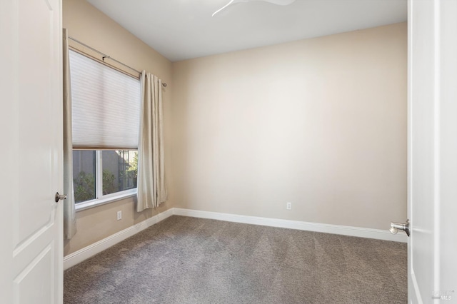 spare room featuring carpet and baseboards