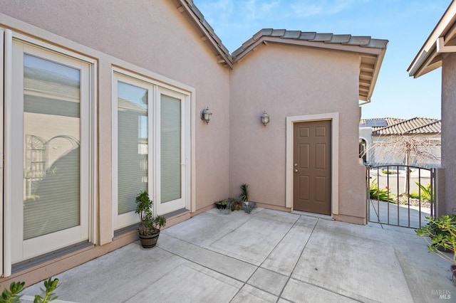 property entrance featuring a patio area and stucco siding