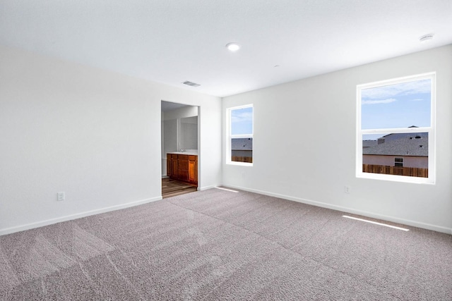 spare room with visible vents, baseboards, and carpet