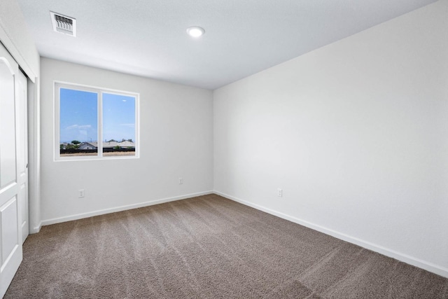 carpeted empty room featuring visible vents and baseboards