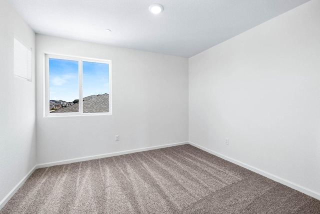 empty room with baseboards and carpet