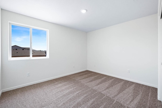 carpeted spare room with baseboards