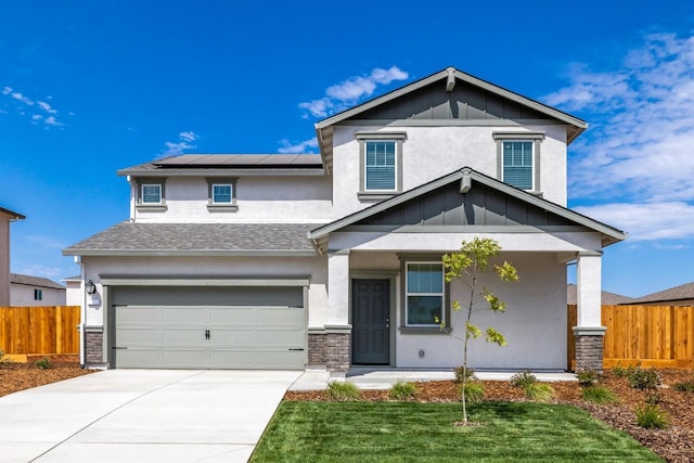 view of front facade with stucco siding, fence, solar panels, an attached garage, and driveway