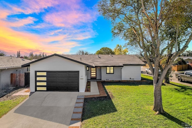 view of front of house with a garage, fence, a lawn, and concrete driveway