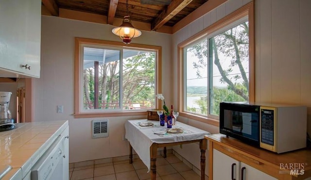 kitchen with white cabinets, dishwasher, tile countertops, decorative light fixtures, and beam ceiling