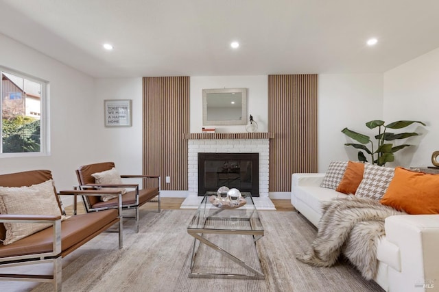 living room with recessed lighting, a fireplace, and light wood-style floors