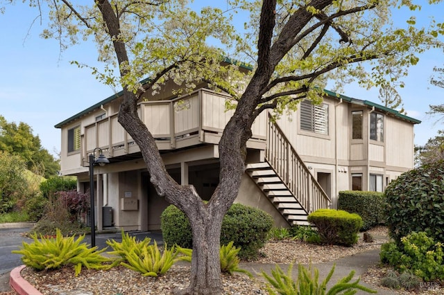 view of building exterior with stairs and central AC unit