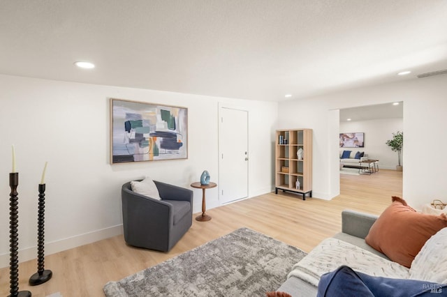 living area featuring recessed lighting, wood finished floors, visible vents, and baseboards