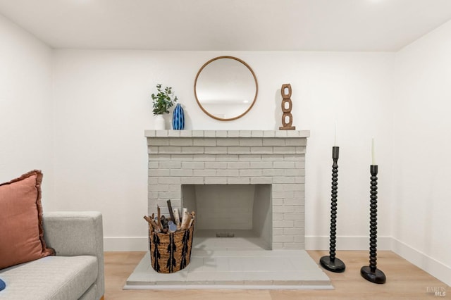 details with a brick fireplace, baseboards, and wood finished floors