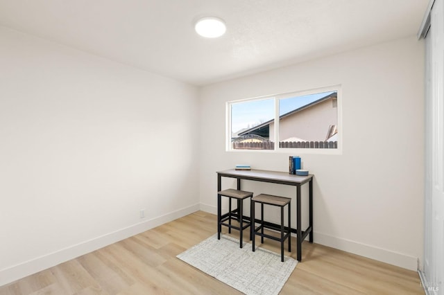 dining room featuring light wood finished floors and baseboards