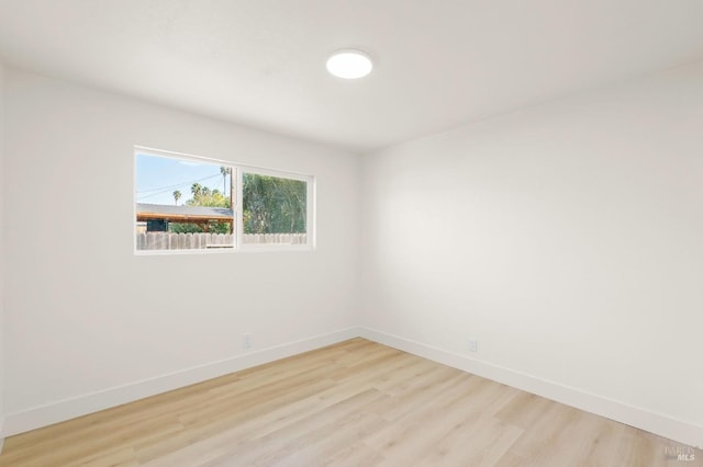 spare room with light wood-style floors and baseboards