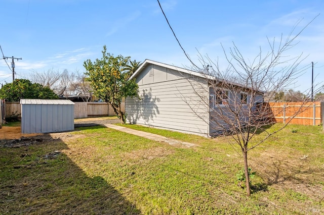 view of yard featuring a shed, an outdoor structure, and fence