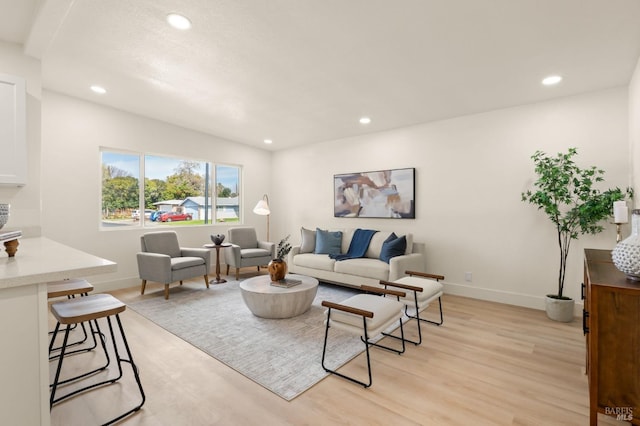 living room with light wood-type flooring, baseboards, and recessed lighting