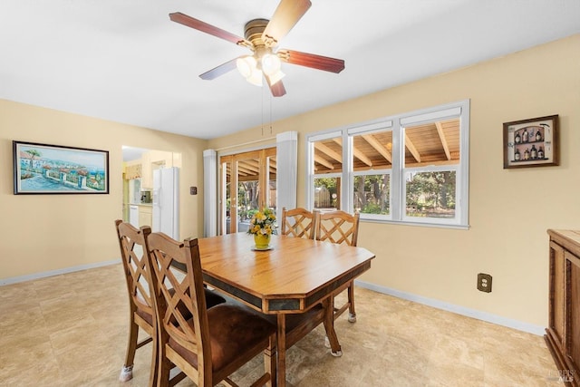 dining space featuring ceiling fan and baseboards