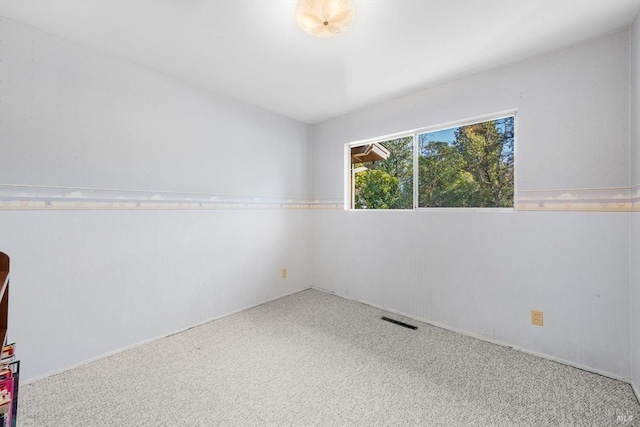 carpeted empty room featuring visible vents