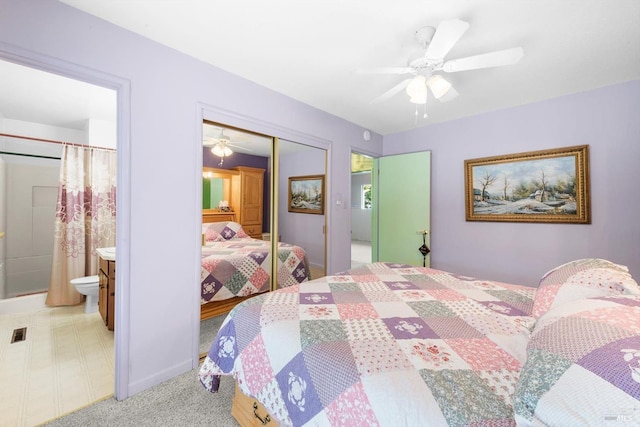 bedroom featuring connected bathroom, a ceiling fan, a closet, and light colored carpet