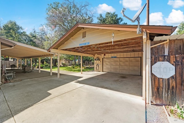 view of parking featuring a garage, driveway, and a carport