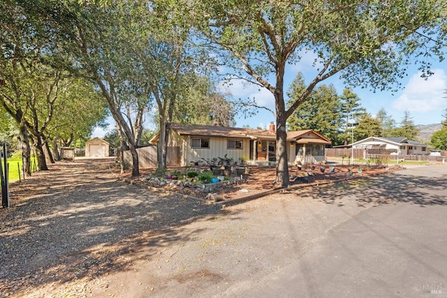 ranch-style home featuring fence