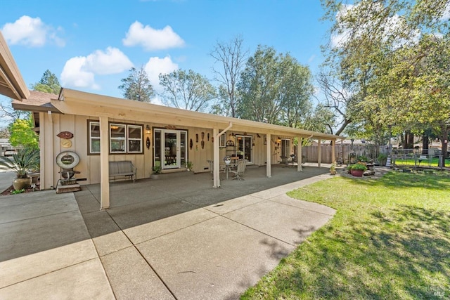 back of property featuring a yard, a patio area, and fence