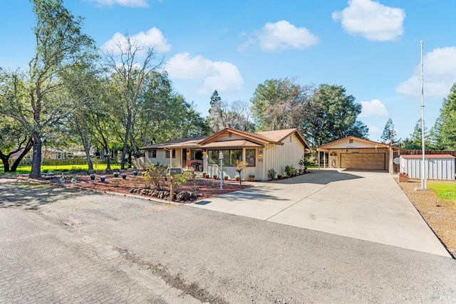 ranch-style house with a porch, a detached garage, and fence