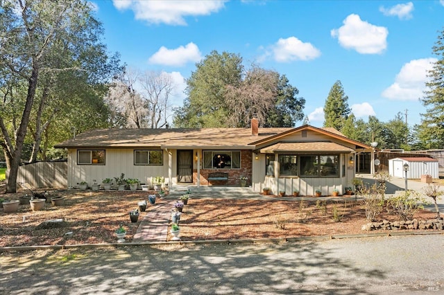 single story home featuring a chimney and fence