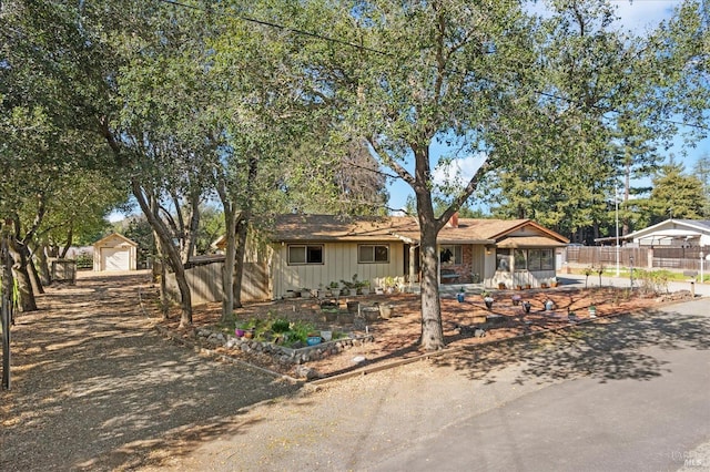 single story home with a garage, fence, and an outbuilding