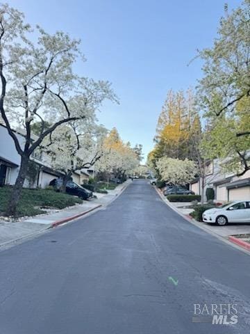 view of road with a residential view and curbs