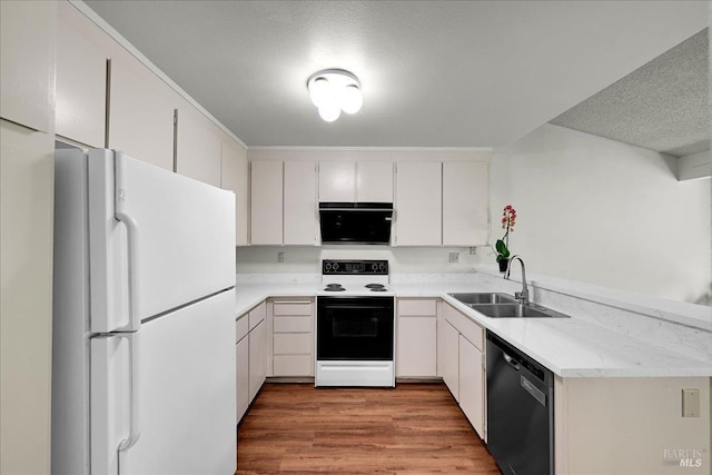 kitchen featuring freestanding refrigerator, wood finished floors, dishwasher, a sink, and range with electric stovetop