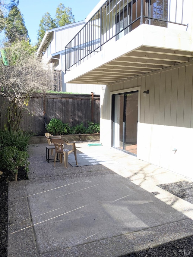 view of patio / terrace featuring fence and a balcony