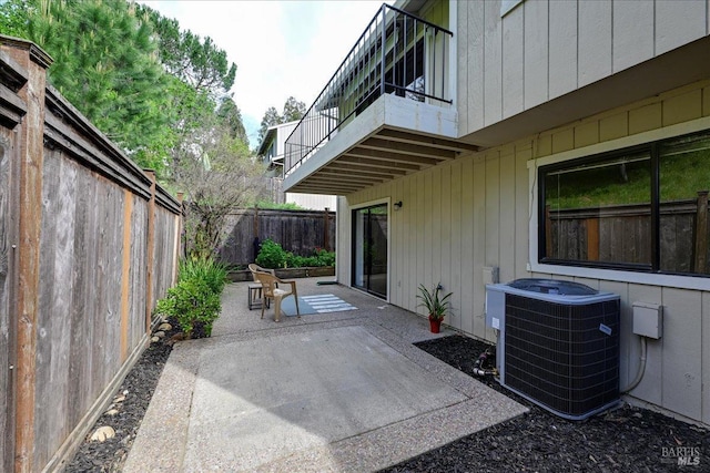 view of patio featuring a balcony, central AC, and fence
