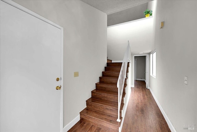 stairway with baseboards and wood finished floors