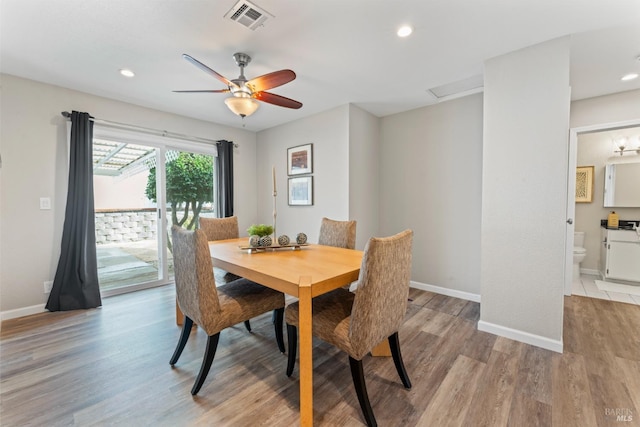 dining room with light wood finished floors, baseboards, visible vents, and recessed lighting