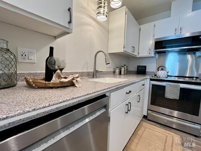 kitchen featuring white cabinetry, appliances with stainless steel finishes, and a sink