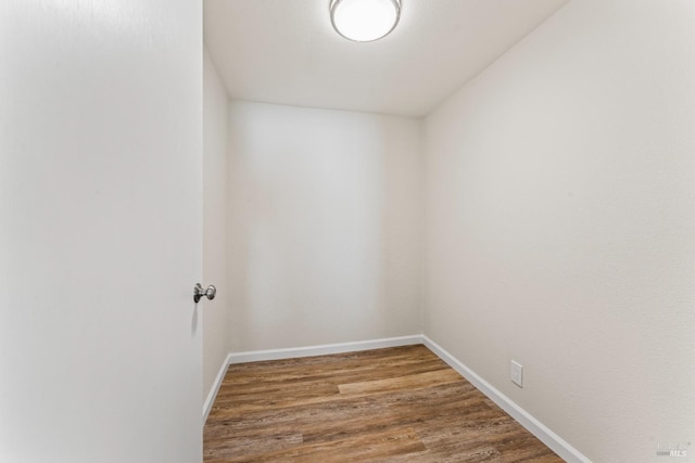 empty room featuring baseboards and wood finished floors