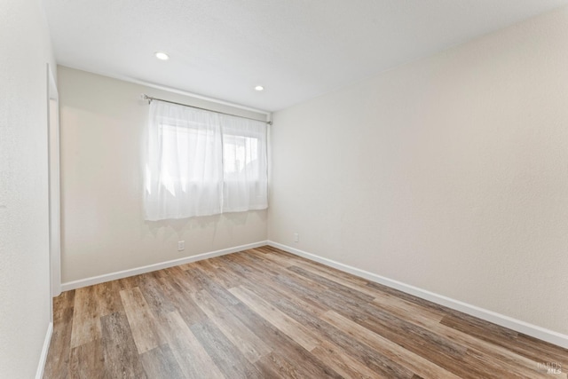 unfurnished room featuring light wood-style floors, recessed lighting, and baseboards