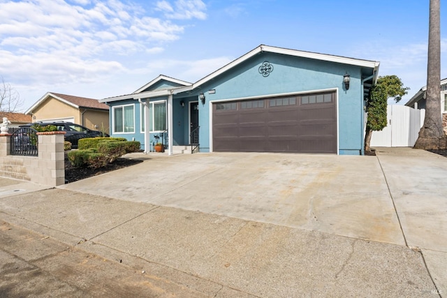 ranch-style house featuring a garage, concrete driveway, fence, and stucco siding