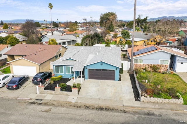 view of front facade with a garage, a residential view, roof with shingles, and driveway