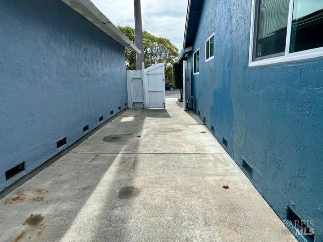 view of home's exterior with crawl space, fence, and stucco siding