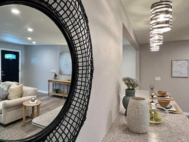 dining area featuring baseboards, arched walkways, wood finished floors, and recessed lighting