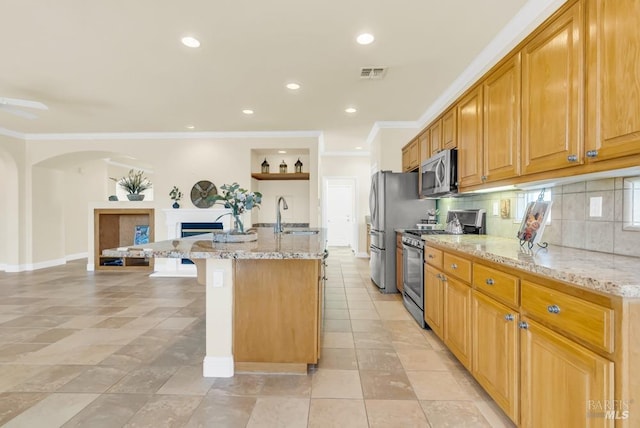 kitchen with visible vents, a sink, appliances with stainless steel finishes, and light stone countertops