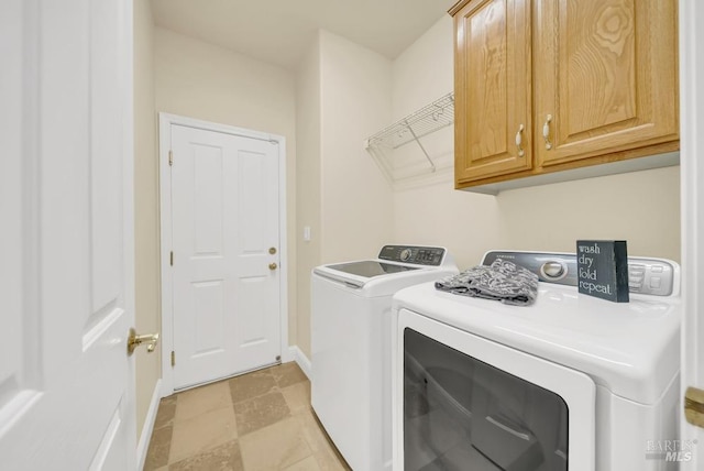 laundry room with baseboards, washer and clothes dryer, and cabinet space