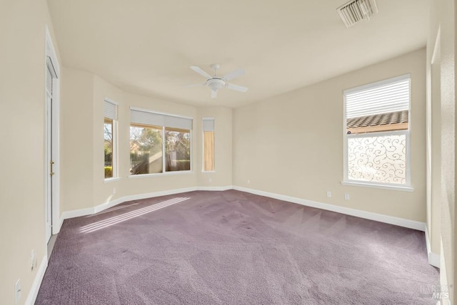 carpeted empty room featuring a healthy amount of sunlight, baseboards, and visible vents