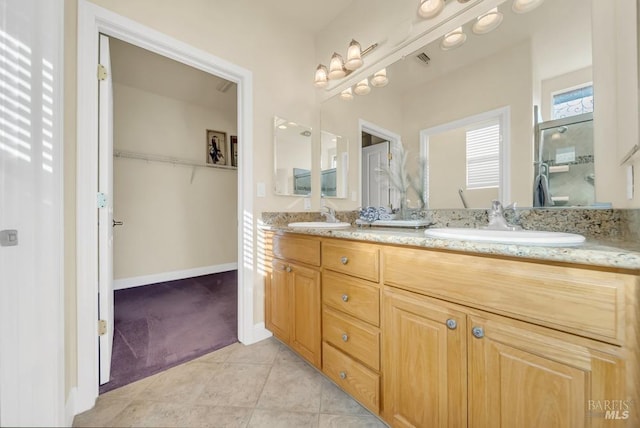 full bath with a sink, tile patterned floors, an enclosed shower, and double vanity