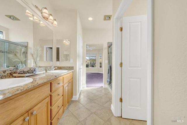 full bathroom with double vanity, a sink, a stall shower, and tile patterned flooring