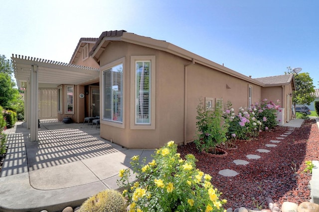 view of side of home featuring a patio area and stucco siding