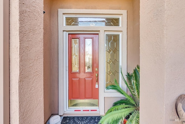 entrance to property with stucco siding