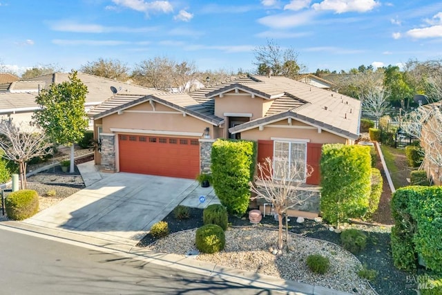 craftsman-style home featuring an attached garage, stone siding, stucco siding, a tiled roof, and driveway